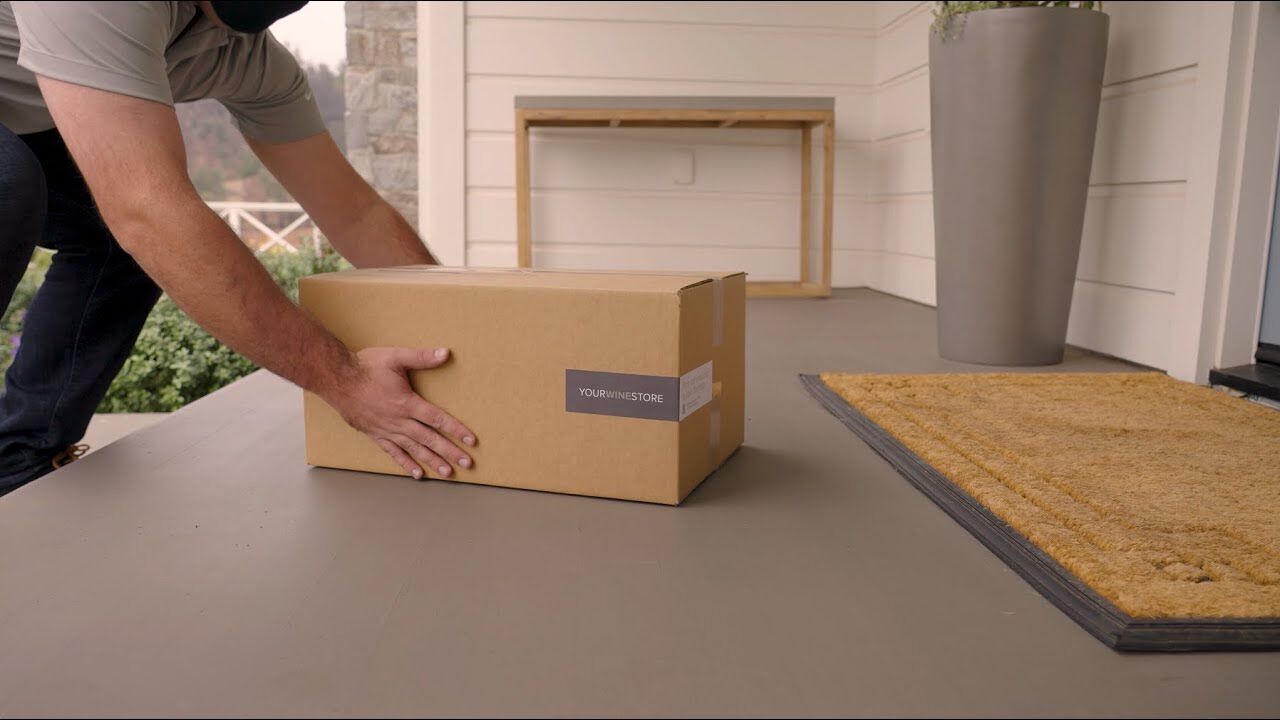 Person delivering wine to front door step